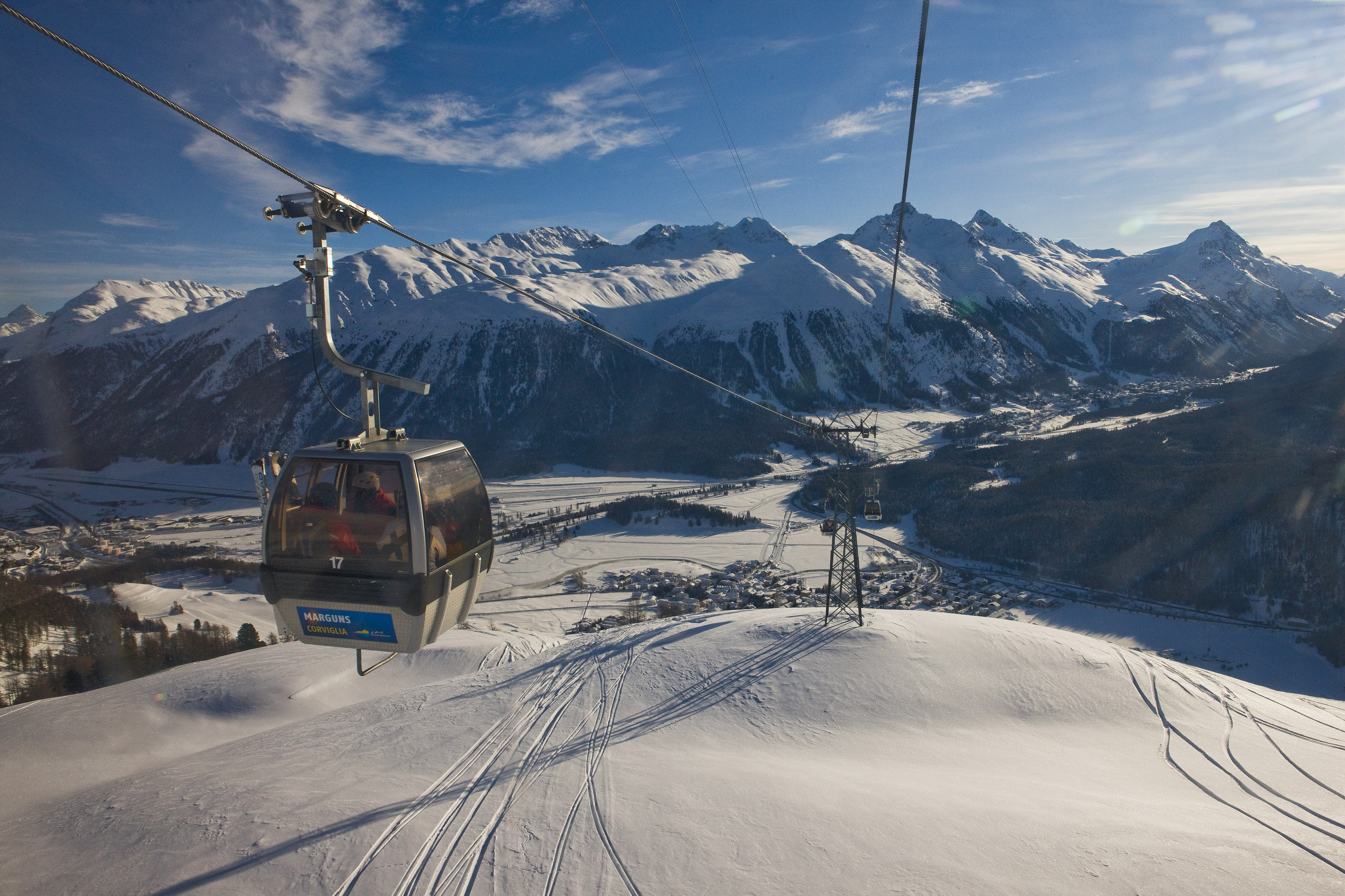 ENGADIN ST. MORITZ - View of the cable car operating between Celerina and Marguns. At the foot of the ski area, the village of Celerina; behind it, the snow-capped mountains and the village of Pontresina. Copyright by ENGADIN St. Moritz By-line:swiss-image.ch/Daniel Martinek