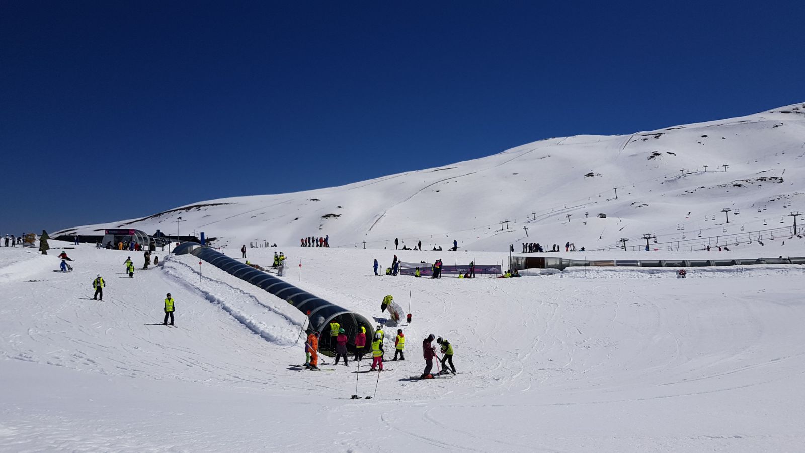 Beginners magic carpet in Sierra Nevada. Sierra Nevada has 70 km of open pistes until the end of this ski season. 