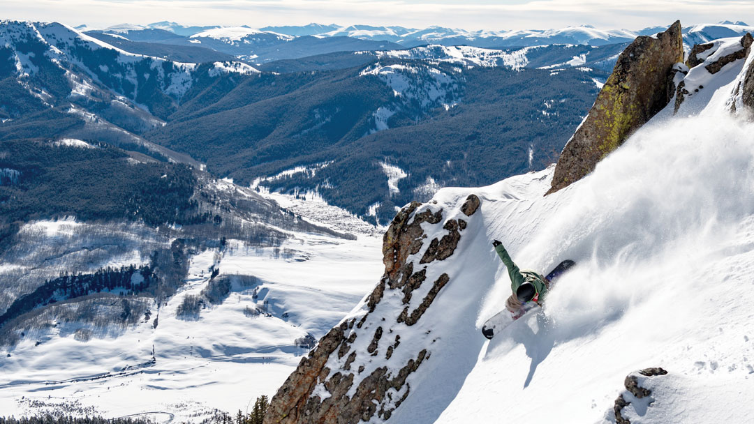A snowboarder goes down a gully at Stevens Pass. Now part of Vail Resorts and the EPIC Pass. 