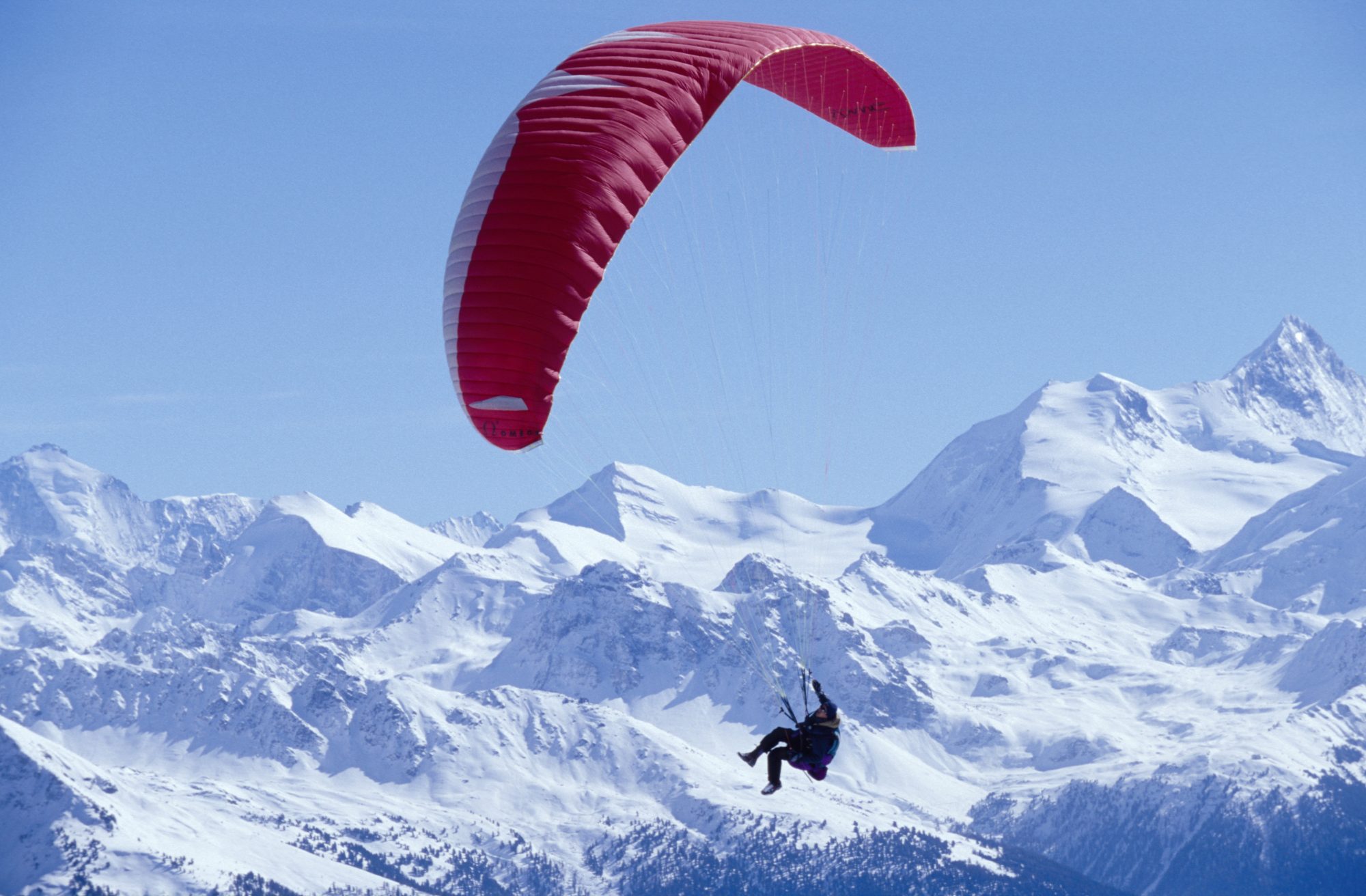 A parapente flying over the Crans Montana valley Photo credit Crans-Montana Tourism Office. How not being scammed when contracting your ski chalet holiday