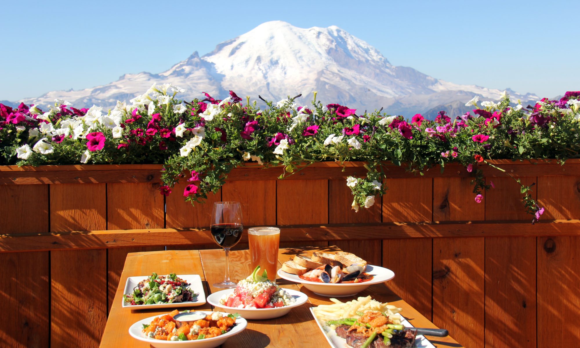 A table with a view of Mount Rainer- Crystal Mountain Resort in Washington state acquired by Alterra Mountain Company.