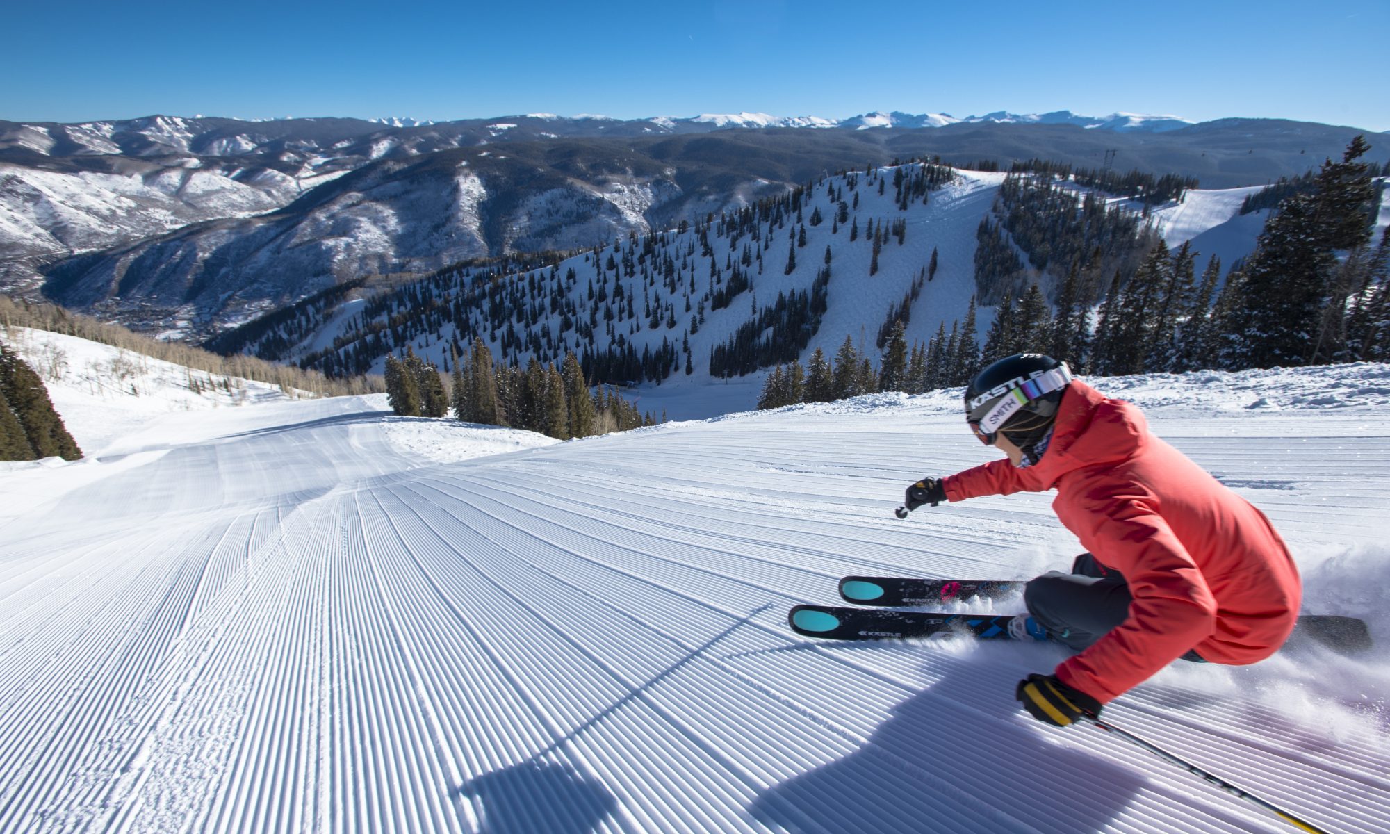 Darcy Conover skiing fresh corduroy down a steep snow covered groomed slope in the mountains at Aspen Mountain Ski Resort in Colorado - Aspen Mountain Announces Bonus Weekend June 1-2, 2019. Photo Aspen Snowmass.