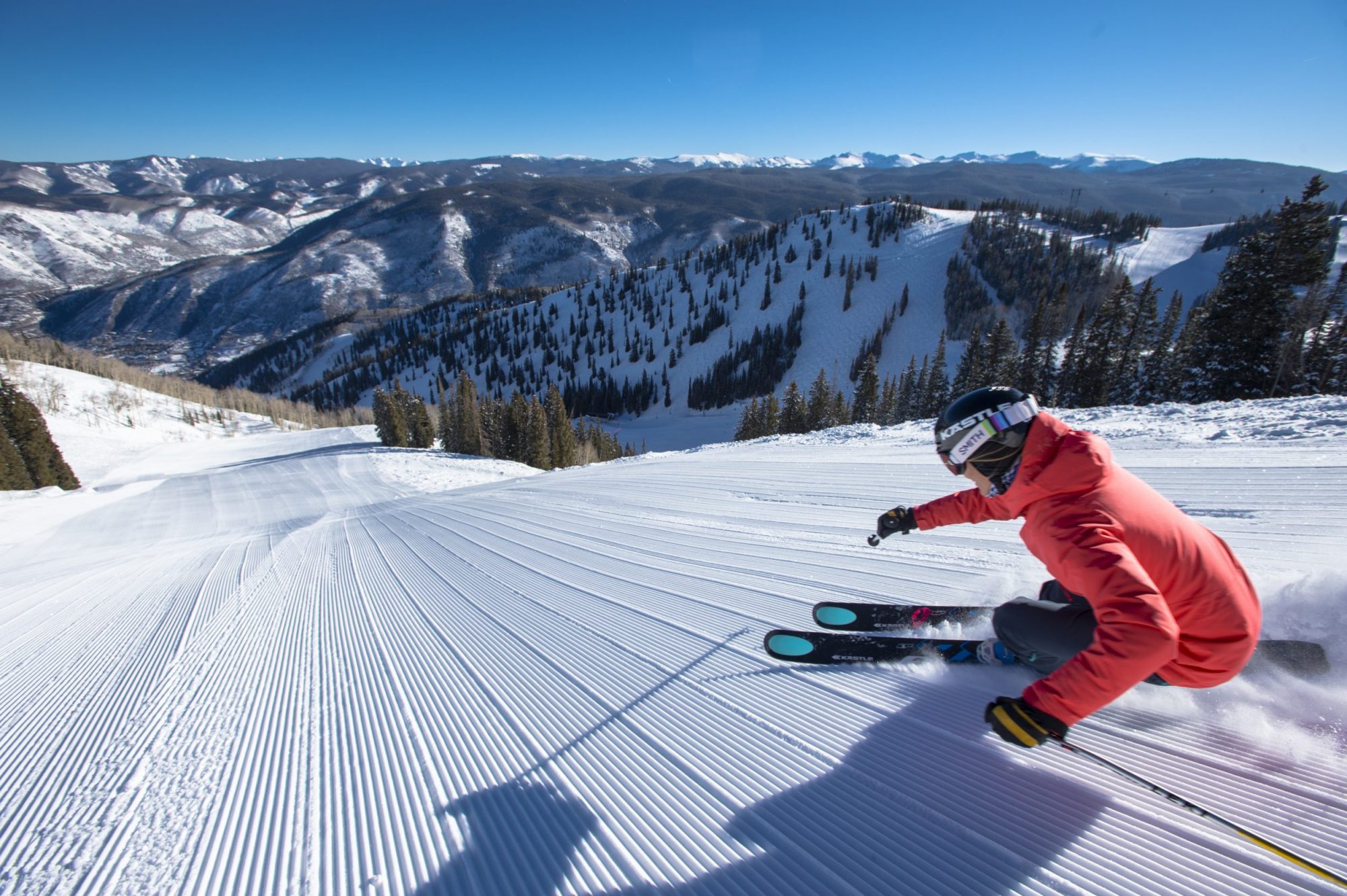 Darcy Conover skiing fresh corduroy down a steep snow covered groomed slope in the mountains at Aspen Mountain Ski Resort in Colorado - Aspen Mountain Announces Bonus Weekend June 1-2, 2019. Photo Aspen Snowmass.