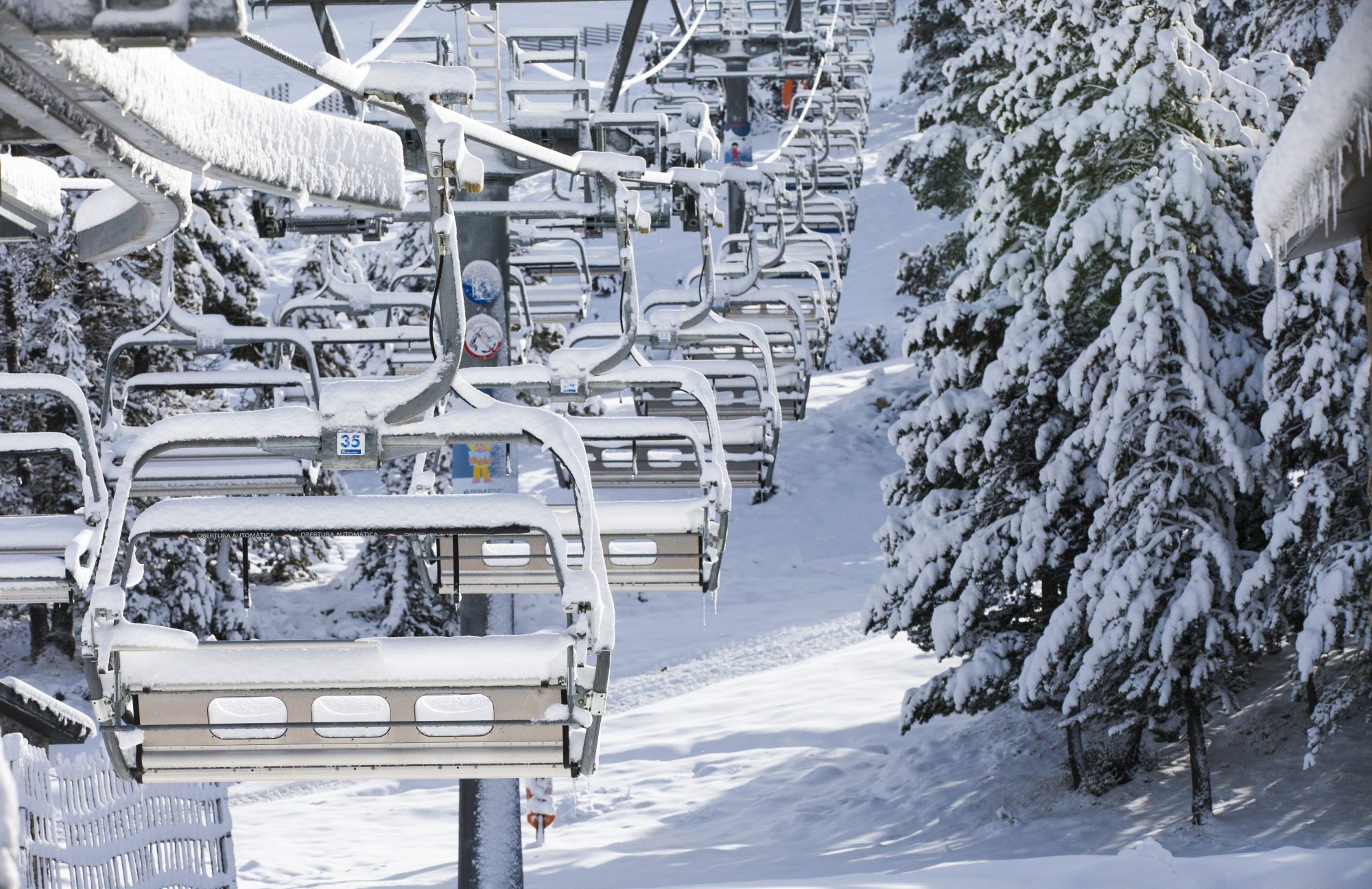 A chairlift in Grandvalira full of snow. The continuity of Grandvalira guaranteed for the long term with the addition of Ordino Arcalís to their skiing experience. - Photo: Grandvalira. 