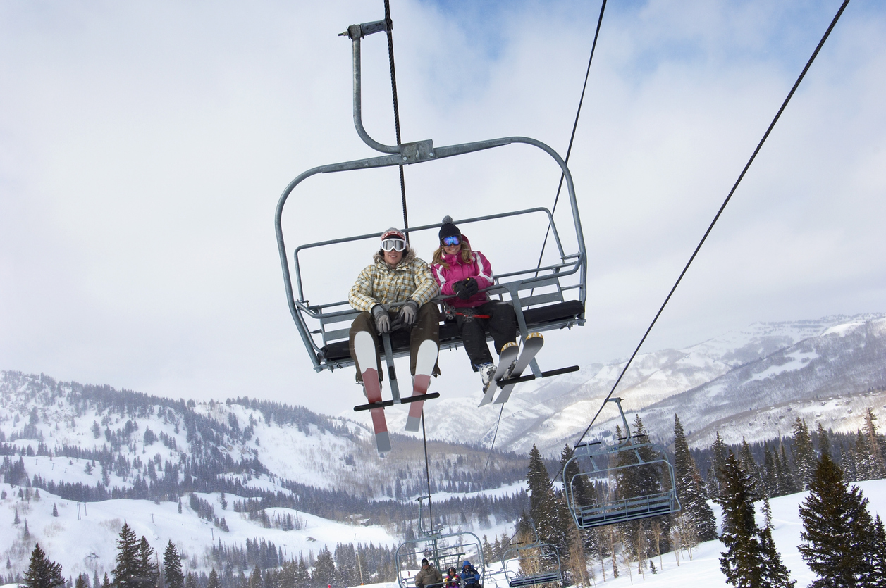 Young Couple on a Chairlift- Photo by ICarhireinsurance.com - Skiers Over New Year Prepare for a £450 Wipeout at the Car Hire Rental Desk.