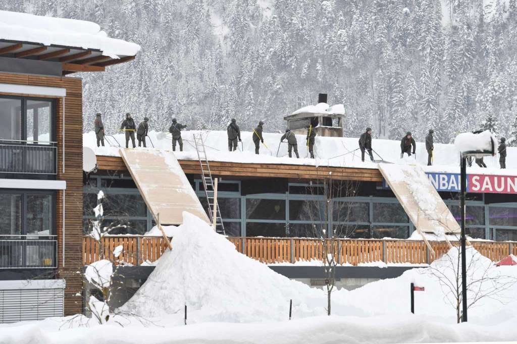 Soldiers cleaning up snow from a roof. Photo: Kerstin Joensson AP. Bundesheer. Two ski patrollers died in Morillon setting avalanche control charges.