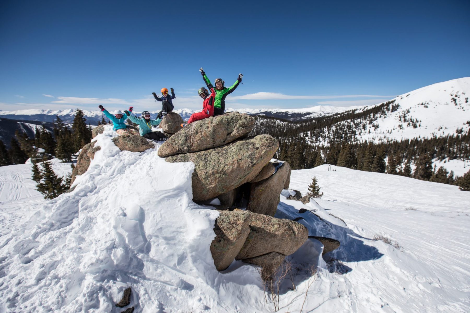 Skiers on rocks, taking a pause after a day of skiing. Photo: Dave Camara. Arapahoe Basin. Arapahoe Basin is now part of the IKON Pass.
