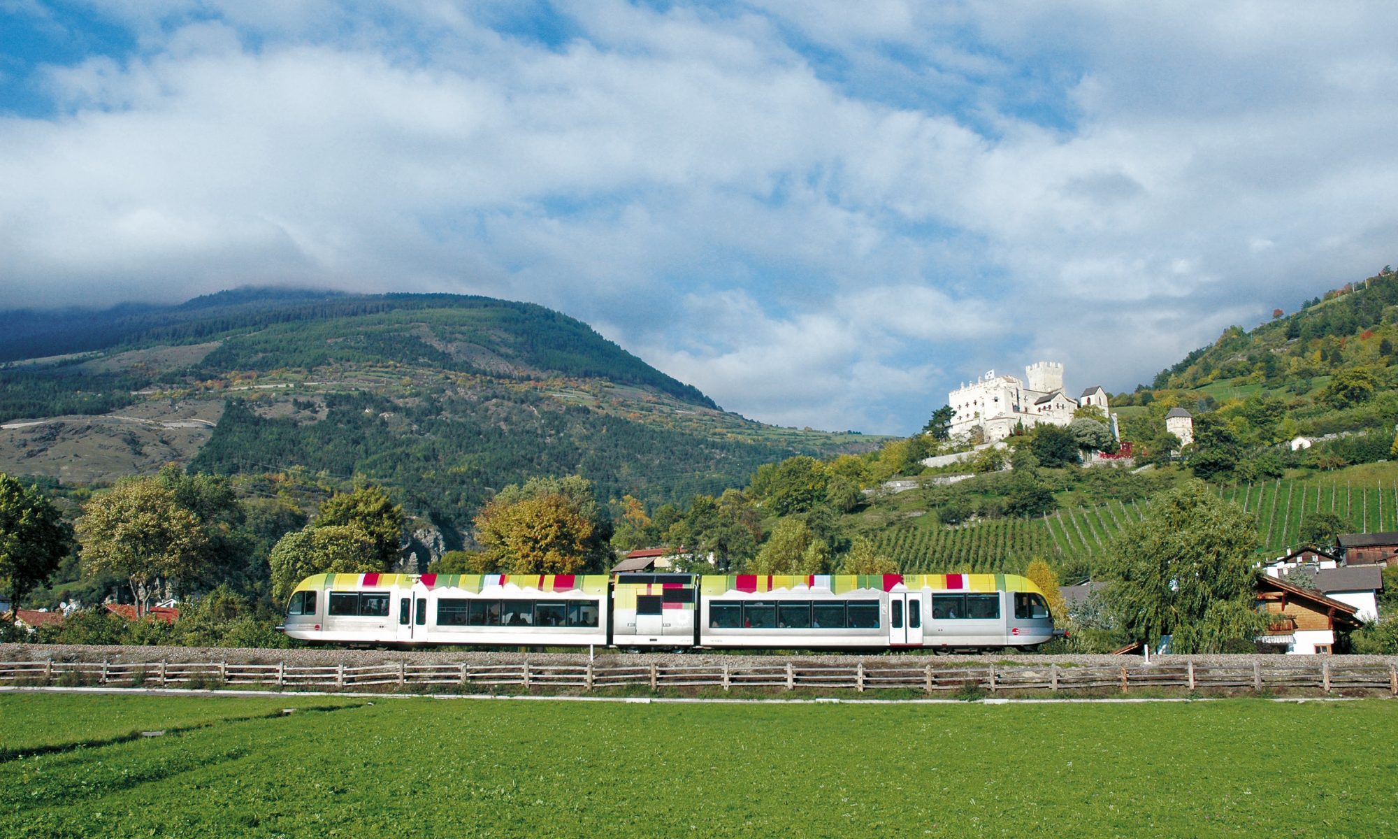 A Dolomites train project could be ready for the 2026 Olympics. This train is one working at Sudtirol. IDM Sudtirol. Photo: Hans-Peter Leu. A unique experience is provided by the new railway line from Merano/Meran to Malles/Mals: the train brings you to Malles, where you can rent a bike and return slightly downhill alongside the orchards and ancient sites of the old Roman trade route Via Claudia Augusta.