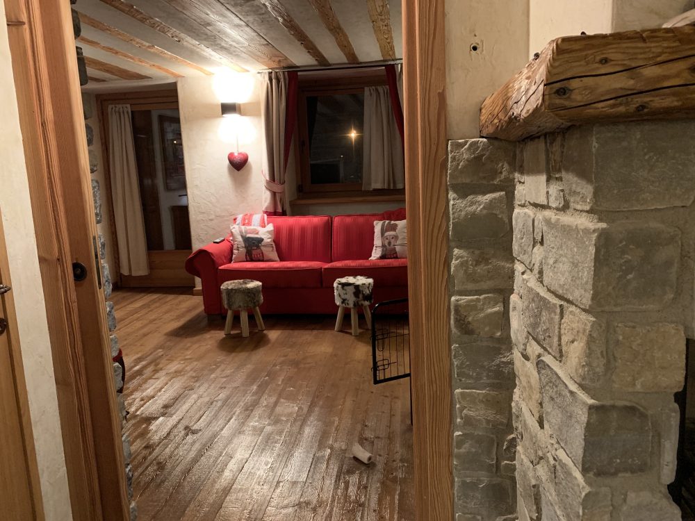 The living room seen from the dining room at Il Cuore della Valdigne. Stay at the Heart of the Valdigne to ski in Courmayeur, La Thuile and Pila/Aosta.