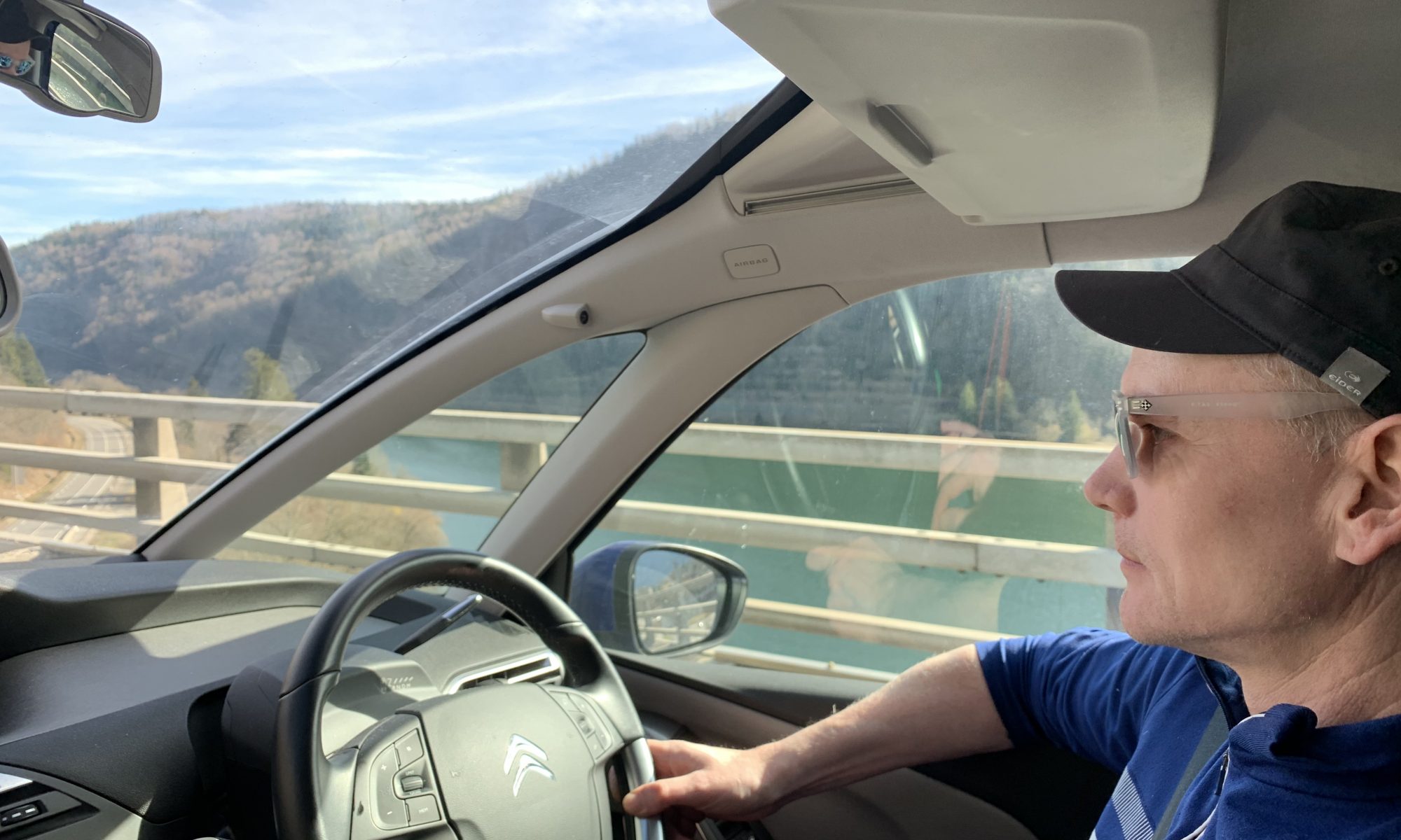 My husband driving over a viaduct near Nantua. How to have a no-contact drive to your summer holiday.