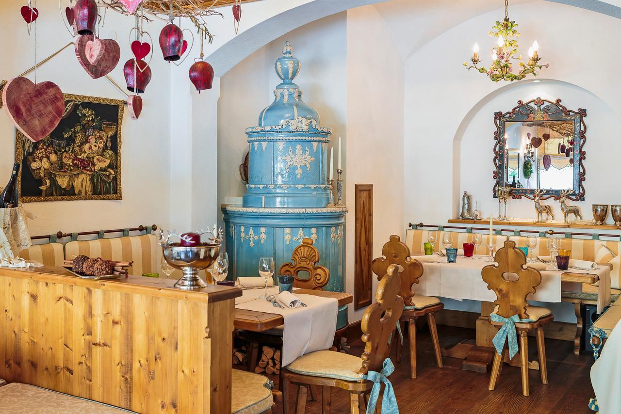 The enamel-painted tiles surrounding the traditional stove at the Cristallino d'Ampezzo. Book your stay at the Hotel Cristallino d'Ampezzo here. Cortina, an example of resilience in the tourism sector.