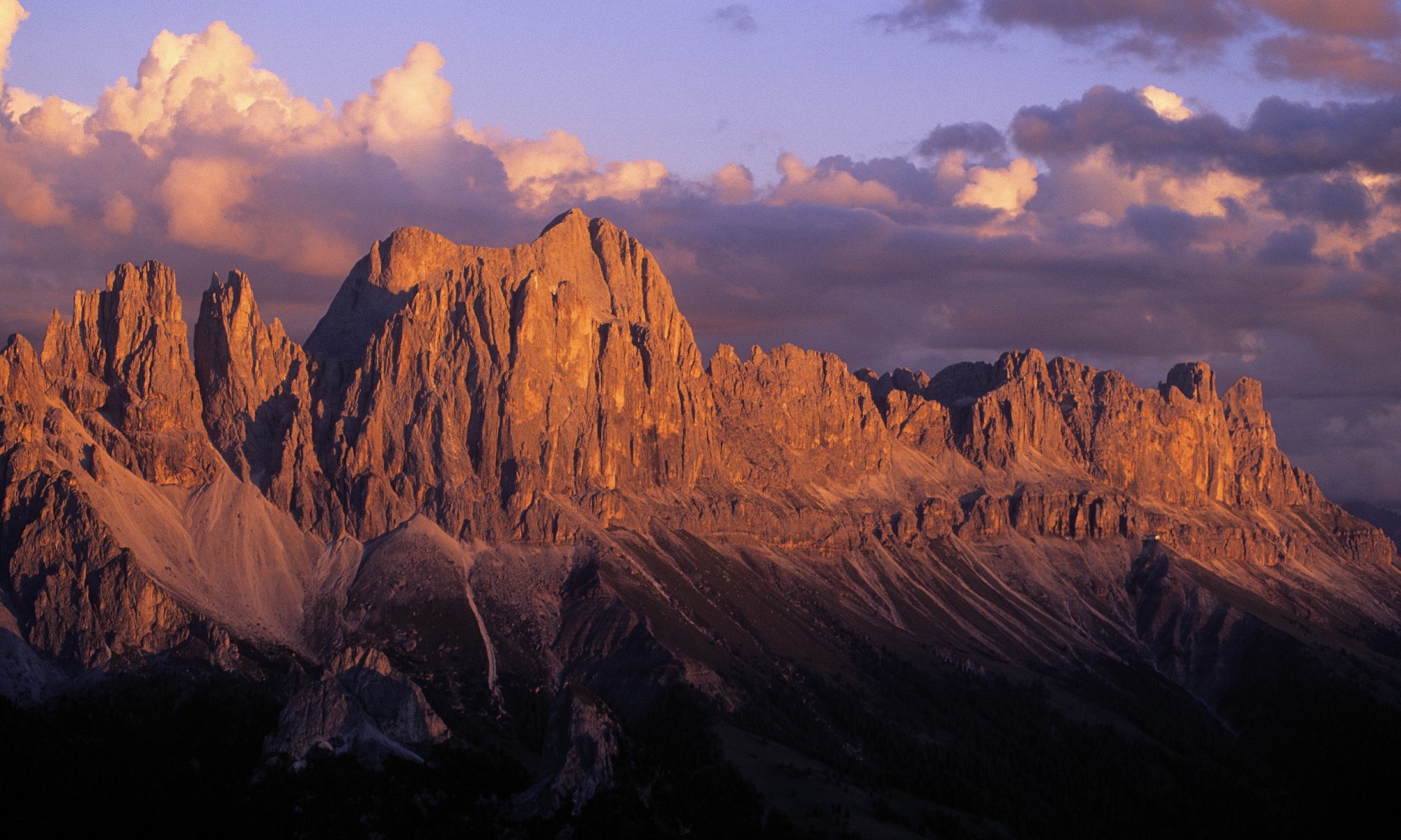 Copyright: IDM South Tyrol / Valentin Pardeller. The Dolomites are a UNESCO World Heritage Site. The rose garden glows impressively in the evening glow on the horizon of the regional capital of Bozen.A Must-Read Guide to Summer in South Tyrol.