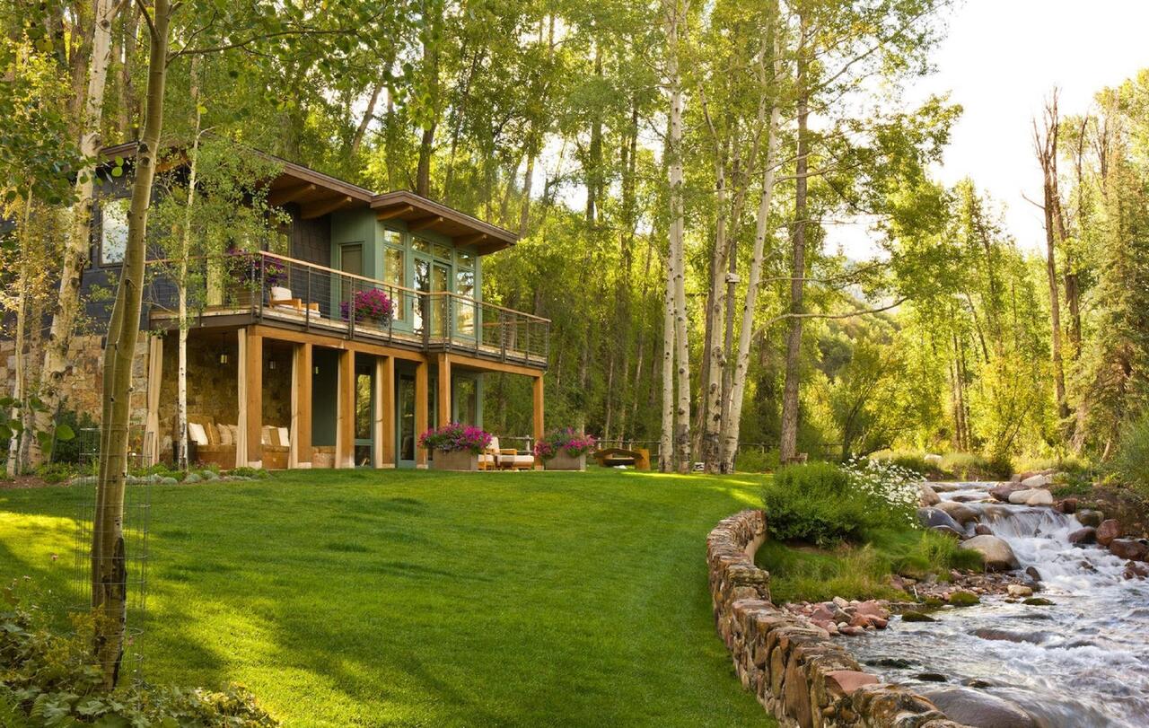 The exterior of the house. Book your stay at this riverfront house in Aspen here. Aspen Snowmass is opening for the Summer Season.
