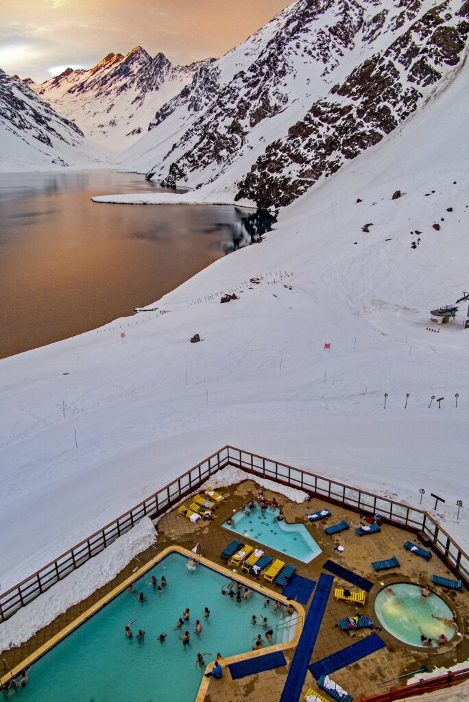 Aereal view of the pool and the Tres Hermanos peaks with the last rays reflections on the Laguna del Inca at Sunset. Photo by Jonathan Selkowitz. Courtesy Ski Portillo. 