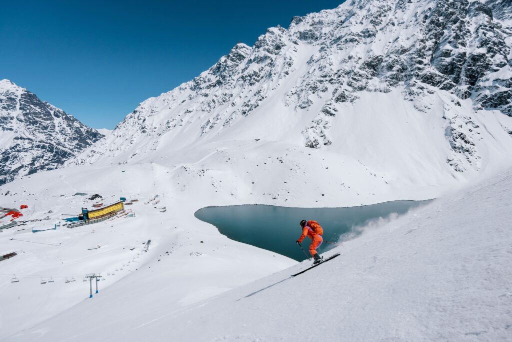 Skier coming down the slopes- views of the hotel and the Laguna del Inca. Photo by Tamara Susa. Courtesy Ski Portillo. 